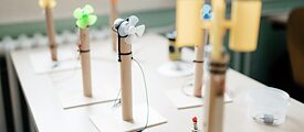 Schüler*innen der Gustav-Langenscheidt-Schule simulieren Windkraft, bringen das Windrad zum Drehen und eine Lampe zum Leuchten.