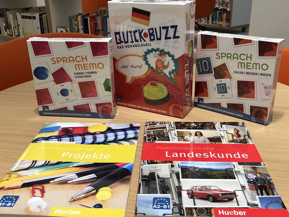 Brettspiele zum Deutsch Lernen liegen in Kartons auf dem Tisch