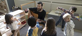 Een leraar speelt gitaar voor zijn leerlingen