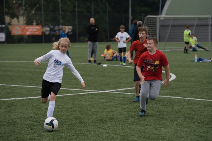 Mädchen und Junge spielen Fußball.