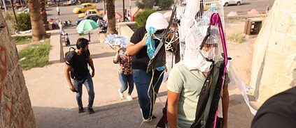 Mehrere Personen mit Masken aus Abfall bei einer Straßenaktion