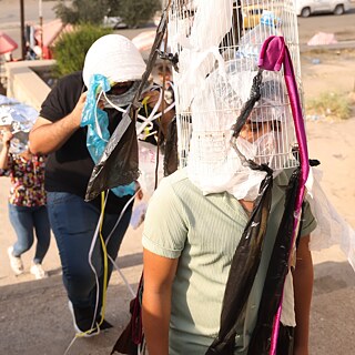 Mehrere Personen mit Masken aus Abfall bei einer Straßenaktion