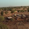 Fermo immagine dal film “Der Waldmacher” (tit. internazionale “The Forest Maker”): piccolo villaggio africano circondato da alberi