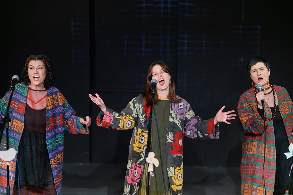 Die drei Sängerinnen des Folk-Ensemble Kriwi singen auf der Bühne