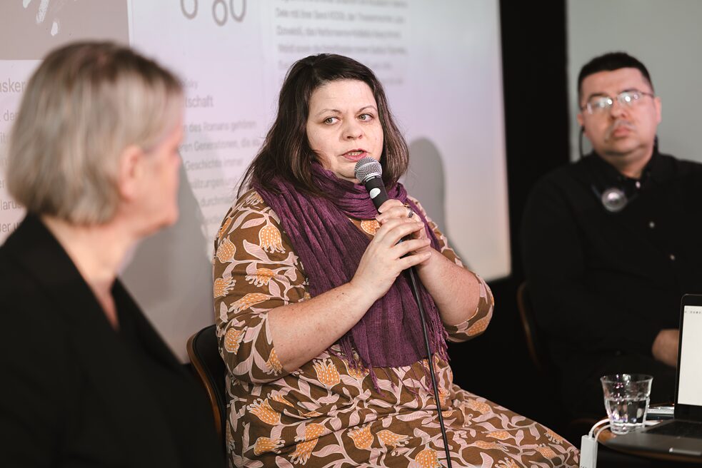 Drei Personen sitzen auf der Bühne und stellen die Aktion „33 Bücher für ein anderes Belarus“ vor