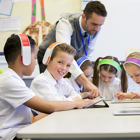 A teacher supervises the digital learning of his pupils