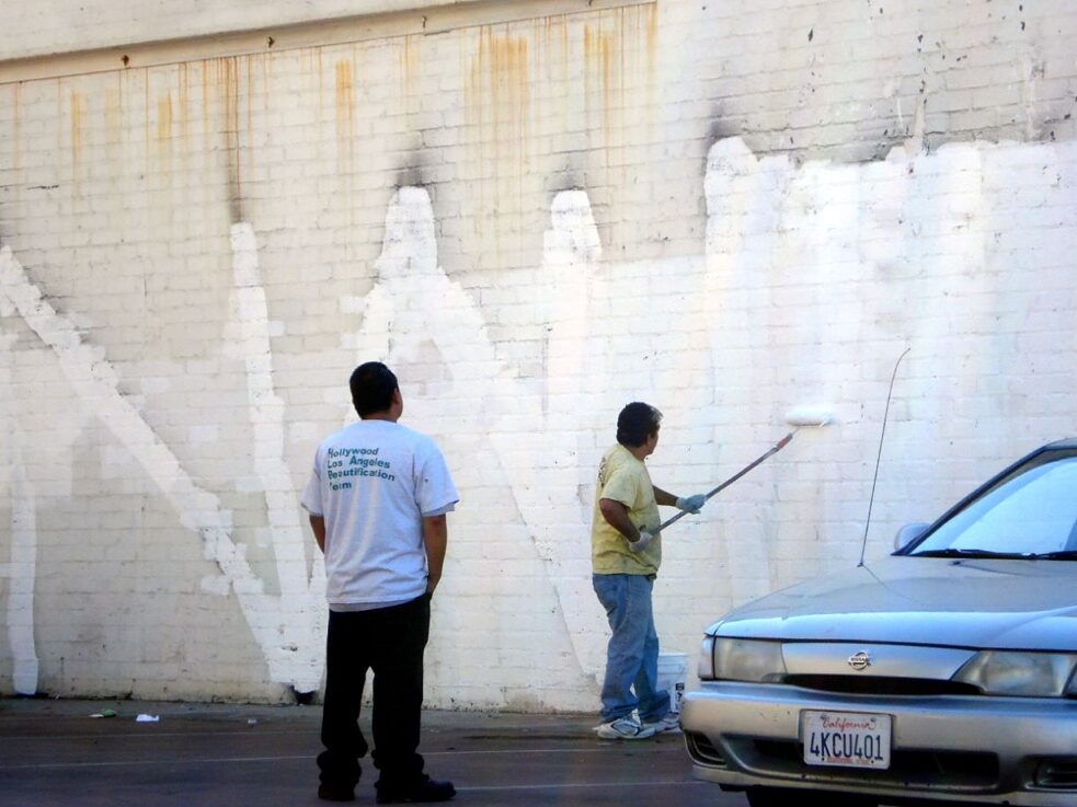 The Subconscious Art Of Graffiti Removal: City workers painting over Graffiti, blissfully unaware of their role as artists and their part in the conversation of public versus private agency and aesthetics.