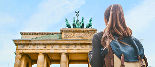 Brandenburger Tor im Hintergrund, Frau mit Rucksack von hinten zu sehen