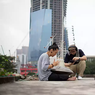 Two artists at a rooftop in Kuala Lumpur recording sounds