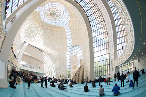 Bangunan baru Masjid Raya di Köln menunjukkan bahwa arsitektur masjid kini tidak lagi terbatas pada lokasi tersembunyi. Bagian interior dihiasi 1.800 lempengan gipsum yang membentuk pola geometris. Sebuah lampu gantung berukuran besar menerangi kaligrafi beraksara Arab.