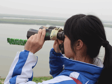 Eine Schülerin der Yueyang Fremdsprachenschule beobachtet Vögel.