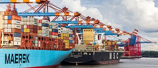 Drei Containerschiffe im Hamburger Hafen.