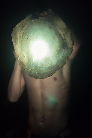 Ein junger Mann untersucht die Haut eines Javelin (dt.: Nabelschwein), die getrocknet und später als Trommel verwendet werden soll.