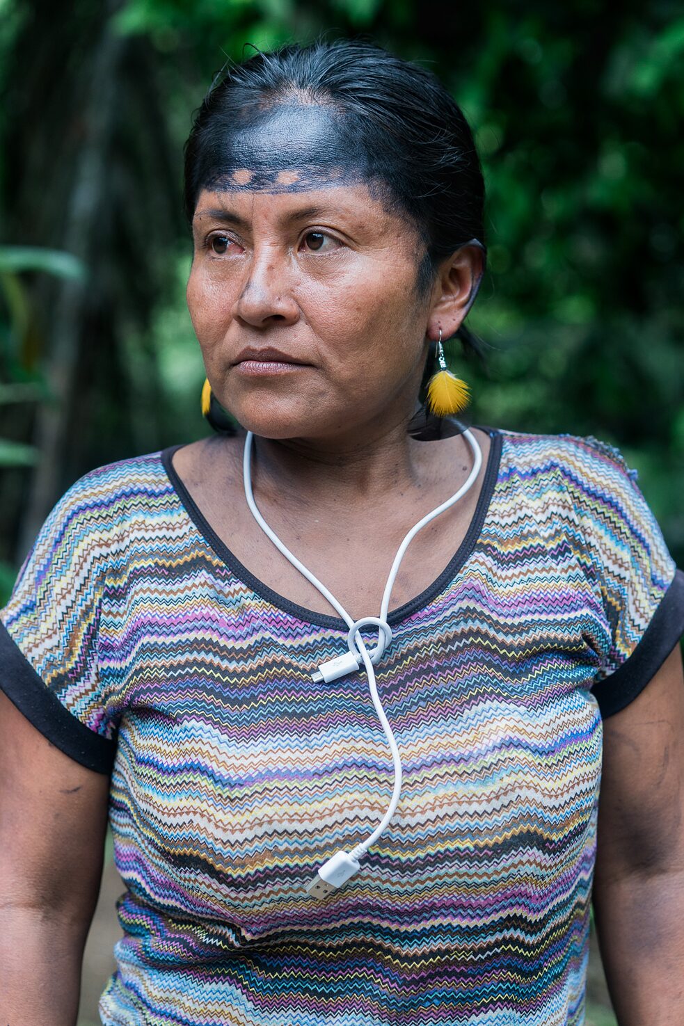 Retrato de Imelda Gualinga de camino a Wayusa Net, una choza con conexión satelital a internet. Es uno de los pocos lugares del pueblo con suficiente energía eléctrica para cargar baterías, celulares y computadoras.