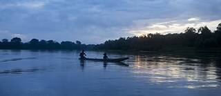 Zwei Miskito paddeln in einem Boot auf dem Wasser des Rio Coco, Nicaragua.