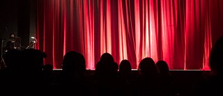 Leute sitzen im Publikum im Theater