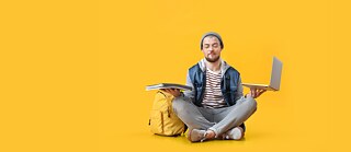 Man with computer learning German portugal