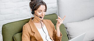 Frau mit Headset und Laptop