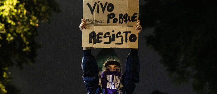Während einer Demonstration für die Entkriminalisierung von Abtreibungen in Argentinien hebt eine Demonstrantin ein Schild mit dem Schriftzug „Ich lebe, weil ich Widerstand leiste“.  