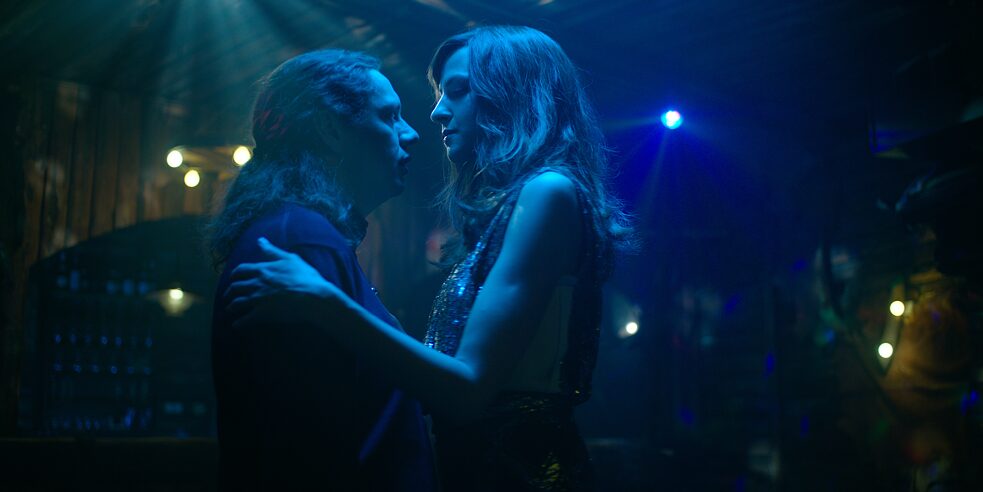 Daniel "Zahnlos" Sluiter (Christian Friedel) und Elena Seliger (Natalia Belitski) tanzen miteinander auf einer dunklen Tanzfläche, sie sehen sich gegenseitig in die Augen.