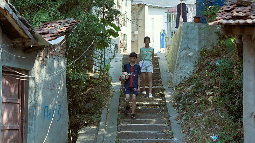 Screenshot vom Film Summer Blur, ein Junge und ein Mädchen auf einer Treppe