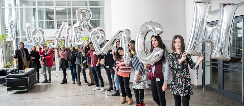 Schüler*innen lachen und halten Luftballons