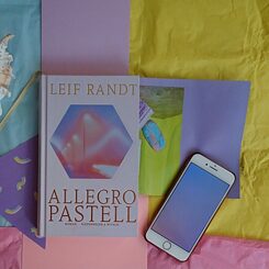 Das Buch "Allegro Pastell" liegt auf einer bunten Decke.