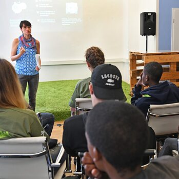 students sit in classroom with teacher