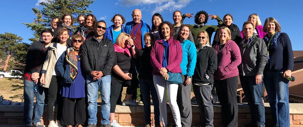 Teachers are standing together and smiling into the camera