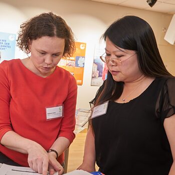 Two people are looking at material