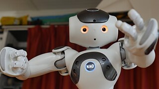 Ein Roboter mit leuchtenden Augen und erhobenen Armen, der zu Lächeln scheint