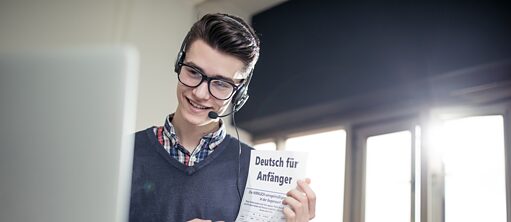 Ein Tutor hält einen Deutschkurs und zeigt den Onlineschülern ein Arbeitsblatt
