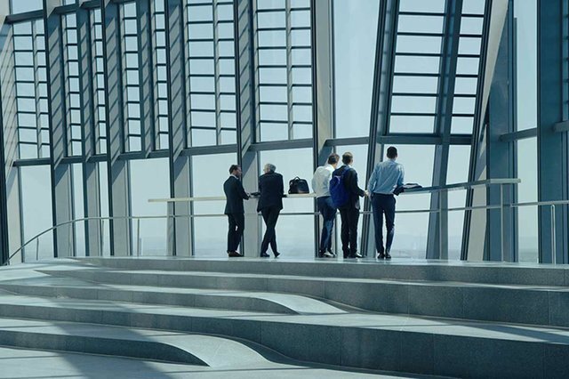 Bankers stand at a window in Carmen Losmann's film Oeconomia