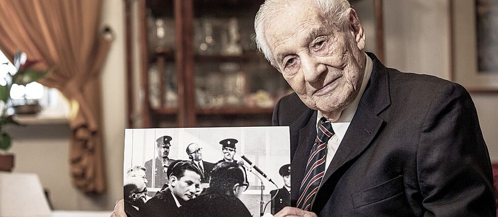 Gabriel Bach, 94, zuhause in Jerusalem. Auf dem historischen Foto ist er in der Bildmitte zu sehen, dahinter Adolf Eichmann im Glaskasten auf der Anklagebank.