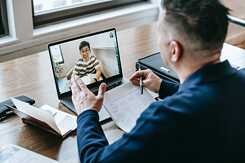 Lehrer und Schüler während im Rahmen eines Online-Unterrichts mit einem Laptop.