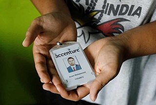 Mohammed Akram, brother of Mohammed Azam, who was killed in a mob lynching attack, poses with the identity card of his deceased brother