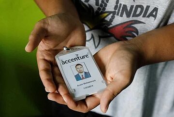 Mohammed Akram, brother of Mohammed Azam, who was killed in a mob lynching attack, poses with the identity card of his deceased brother