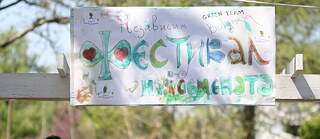 Fotografie von gemaltem Logo von Green Team Bulgaria, blau-grüne wasserfarbene Buchstaben auf weißem Blatt Papier