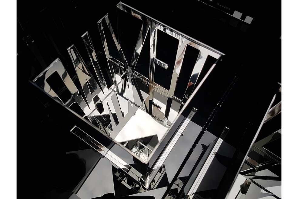 Marion Jungeblut im KunstRaumGoethe Beschreibung: Eine Kunstinstallation stellt das deutsche Wort „ZEIT“ vierdimensional dar. Die Oberflächen reflektieren sich und erzeugen somit eine abweichende Wirklichkeit.