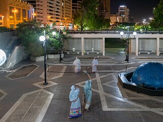 شابات من جماعة "بوري" يمارسن لعبة الريشة الطائرة حيث ربطن الشبكة بعمود الإضاءة في أحد الأماكن العامة بمتنزه في منطقة ديرة. يعود هذا المتنزه إلى حقبة الثمانينات عندما كانت هذه المنطقة أحد المناطق الغنية والفخمة.