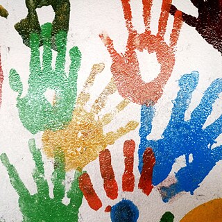 Gros plan d'un mur de maison avec un graffiti à partir de mains colorées