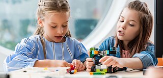 Zwei Mädchen machen einen Roboter