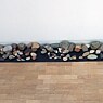 Annea Lockwood, A Sound of the Danube, installation view at the Stadthaus, Ulm, Germany 2006: River stones are displayed near the wall.s near the 