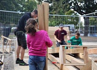 การอนุญาตให้มีส่วนร่วม – เยาวชนกำลังสร้างที่นั่งไม้ที่สถานที่ก่อสร้างแบบมีส่วนร่วม 
