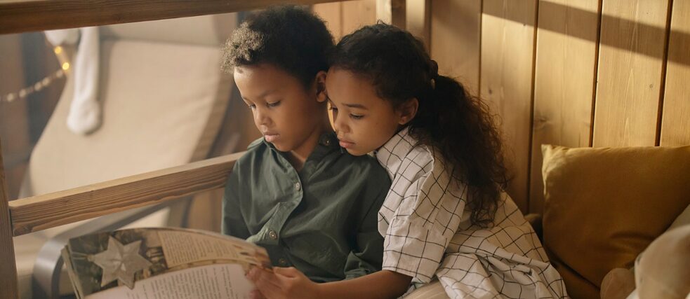 Zwei Kinder lesen ein Buch.