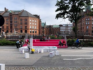Spazio per andare in bici e giocare sottratto alle automobili: esperimenti reali come questo di Amburgo mostrano concretamente cosa può voler dire eliminare le auto dalla città.
