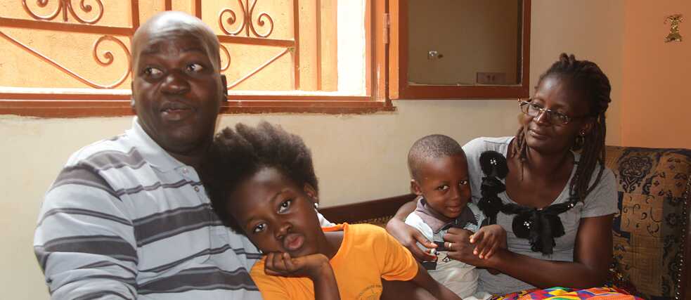 La famille Sama assise ensemble sur le canapé