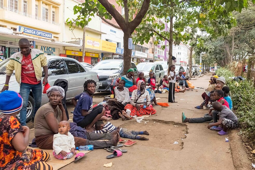 Mehrere Personen sitzen zusammen auf einer Straße in Kenia's Hauptstadt Nairobi