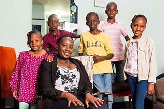 Die Kinder der Familie versammeln sich um die 39-jährige Zainabu