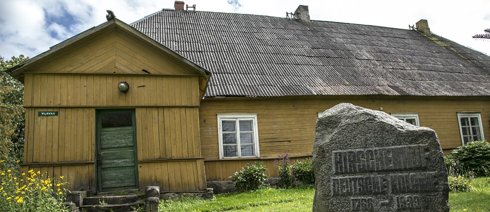 Gemeindehaus mit dem Gedenkstein für die ehemalige deutsche Kolonie Hirschenhof.